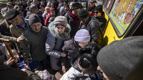 People wait for a bus to go in a train station in Severodonetsk, eastern Ukraine. More than 4 million people have now fled Ukraine to seek shelter in EU countries, while 6.5 million people have fled their homes but remain inside Ukraine, the European Commisison said.(Photo by FADEL SENNA / AFP)