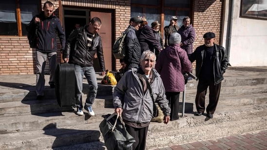 People wait for a bus with their luggage a day after a rocket attack at a train station in Kramatorsk, on Saturday.Poland hosts by far the largest number of refugees. Since the invasion, 2,564,994 have entered Poland, according to the UNHCR.(Photo by FADEL SENNA / AFP)