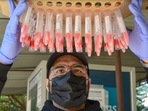 A health worker with swab samples collected for Covid-19 test, in Gurugram.