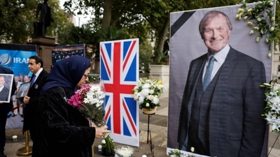Members of the Anglo-Iranian community and supporters of the National Council of Resistance of Iran (NCRI) attend a memorial service to pay tribute to slain British lawmaker David Amess in Parliament Square in front of the Houses of Parliament in central London. (AFP)