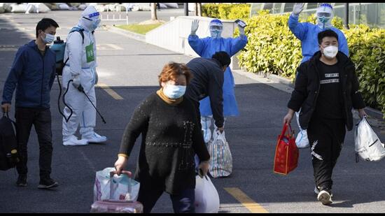 The first group of patients who have recovered from Covid-19 leave a makeshift hospital converted from Shanghai Convention & Exhibition Center of International Sourcing in Shanghai. (AP)