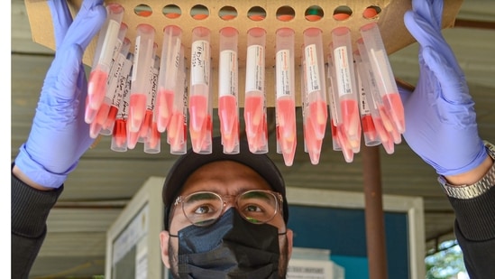 A health worker with swab samples collected for Covid-19 test, in Gurugram.(PTI)