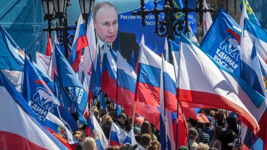 People wave flags during a rally in support of the Russian military operation in Ukraine, in Simferopol, Crimea on Thursday.(AFP)