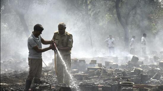 Firefighters douse the flames at a cow shelter in Kanawani village in Ghaziabad on Monday. (Sakib Ali/ HT)