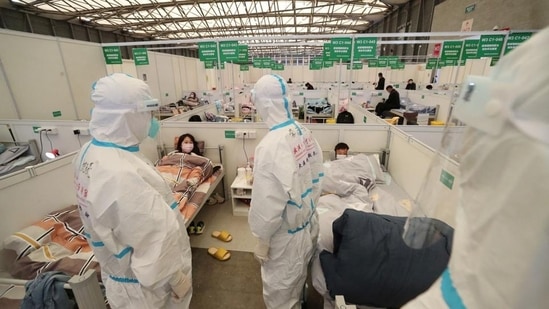 Medical workers in protective suits conduct ward rounds at Shanghai New International Exhibition Hall, which has been turned into a makeshift hospital for Covid-19 patients, in Shanghai, China. (REUTERS)