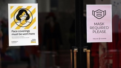 Signs reminding customers to wear protective masks at an entrance to a store. (Bloomberg) Signs reminding customers to wear protective masks at an entrance to a store. (Bloomberg)
