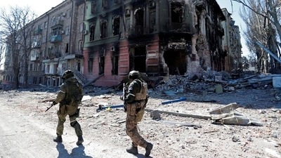A resident walks near a building destroyed in the course of the Ukraine-Russia conflict, in the southern port city of Mariupol, Ukraine. (REUTERS)