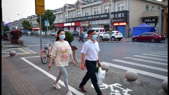 Residents walk on a street in Fengjing town of Jinshan district, as the city eases the lockdown in some areas amid Covid-19 outbreak, in Shanghai, China. (REUTERS)