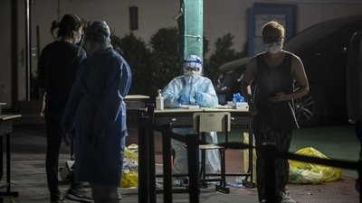 A medical worker prepares to test residents during a round of Covid-19 testing in a neighborhood placed under lockdown in Shanghai. (Bloomberg) A medical worker prepares to test residents during a round of Covid-19 testing in a neighborhood placed under lockdown in Shanghai. (Bloomberg)