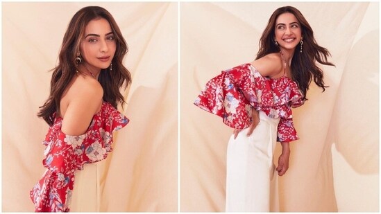 Rakul Preet matched her Runway 34 promotions outfit with the season and wore a red cold shoulder floral ruffle crop top and wide white trousers.(Instagram/@rakulpreet)
