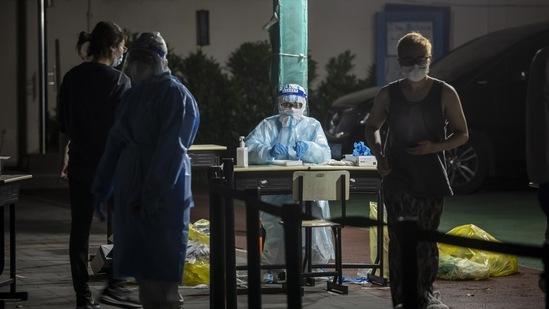 A medical worker prepares to test residents during a round of Covid-19 testing in a neighborhood placed under lockdown in Shanghai.(Bloomberg)