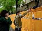 FILE PHOTO: People pass edible oil over the barriers at a street market under lockdown amid the coronavirus disease (COVID-19) pandemic, in Shanghai, China.&nbsp;