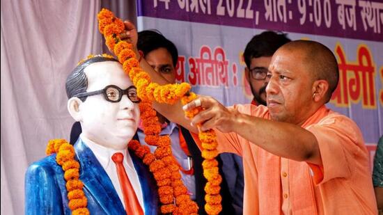 Uttar Pradesh chief minister Yogi Adityanath offering floral tribute to a bust of Dr BR Ambedkar in Lucknow. (ANI PHOTO)