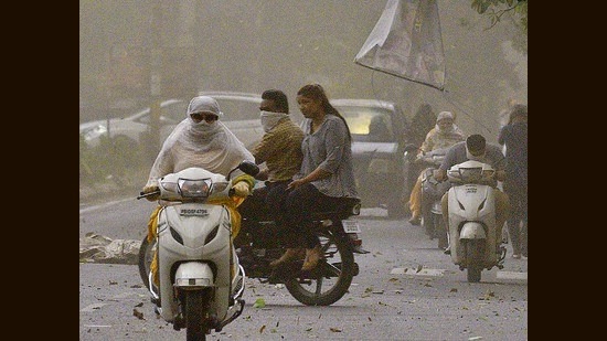 Commuters brave the gusty wind in Ludhiana on Thursday. (Gurpreet Singh/HT)