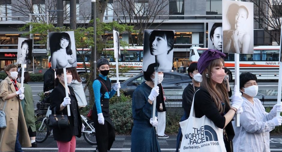 Protesting prejudice: women carrying placards featuring pictures of cancer survivors(Aimie Eliot)