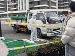中国、上海の浦東にある近隣の住宅化合物がコロナウイルス病（Covid-19）隔離施設に変わったことに住民が抗議しているため、ハズマットスーツを着た警察官がフェンシングを輸送する車両のそばに立っています（ロイター経由）