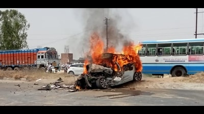 The car that caught fire after crashing into a truck near Istana village on the Panipat-Rohtak highway on Friday. (HT Photo)