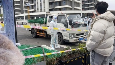 Police officers in hazmat suits stand by a vehicle transporting fencing, as residents protest over neighbouring residential compounds being turned into coronavirus disease (Covid-19) isolation facilities, in Pudong, Shanghai, China. (via REUTERS)