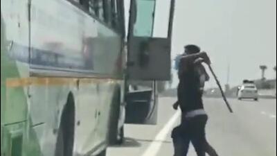 The two men take turns to hit the driver, who is still seated inside. Bus passengers look on. (Sourced) The two men take turns to hit the driver, who is still seated inside. Bus passengers look on. (Sourced)