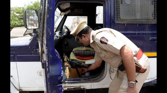 Senior police inspector, Ravindra Patil, from NRI Coastal Police Station, inspects the vehicle used to carry cash to be uploaded in ATM machines on Thursday. The driver was arrested on Friday from Panvel. (BACHCHAN KUMAR/HT PHOTO)