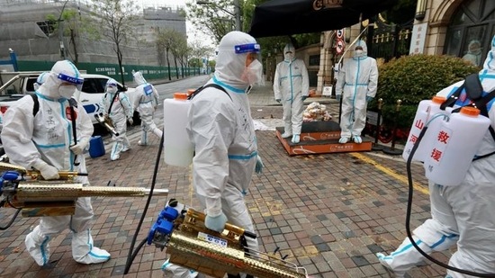 Volunteers in protective suits prepare to disinfect a residential compound in Huangpu district, to curb the spread of Covid-19, in Shanghai, China, on Thursday. (REUTERS)