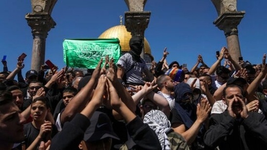 Palestinians chant slogans and wave Hamas flags during a protest against Israel, in front of the Dome of the Rock shrine at the Al Aqsa Mosque compound in Jerusalem's Old City.(AP)