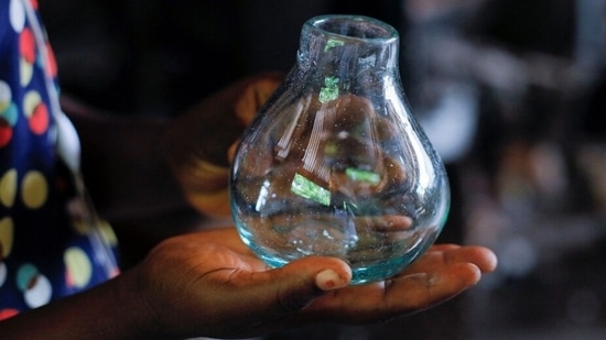 Glassblower Janet Offei, 28, holds a piece of glassware produced at Michael Tetteh's glassware manufacturing workshop in Krobo Odumase, Ghana March 18, 2022.&nbsp;(REUTERS/Francis Kokoroko)