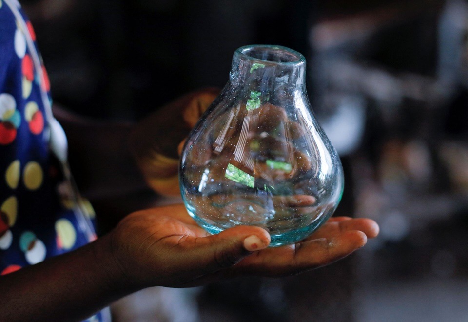 Glassblower Janet Offei, 28, holds a piece of glassware produced at Michael Tetteh's glassware manufacturing workshop in Krobo Odumase, Ghana March 18, 2022.&nbsp;(REUTERS/Francis Kokoroko)