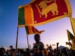 A man carrying a child on his shoulders joins others in an ongoing anti-government demonstration near the president's office in Colombo.(AFP) A man carrying a child on his shoulders joins others in an ongoing anti-government demonstration near the president's office in Colombo.(AFP)