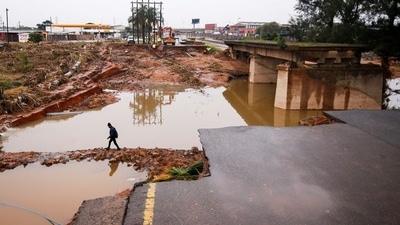 A man walks around a damaged bridge caused by flooding in Umlazi near Durban, South Africa. (REUTERS)