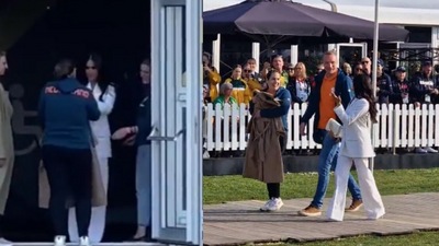 Meghan Markle gives her coat to a woman during her Invictus Games visit on Friday.