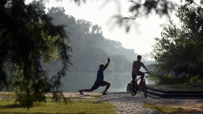 A man performs yoga on a hazy morning at Sanjay Lake in New Delhi. (Hindustan Times)