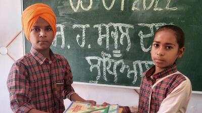 A senior students donating book to a junior students of government school in Ludhiana. (HT PHOTO) A senior students donating book to a junior students of government school in Ludhiana. (HT PHOTO)