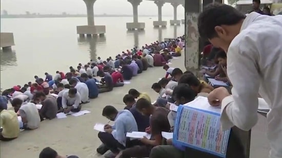 Government job aspirants studying at the bank of a Ghat near Patna University in Bihar.(ANI)