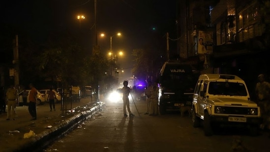 Police personnel stand guard after clashes broke out during a Hindu religious procession in Jahangirpuri area of New Delhi.(REUTERS)