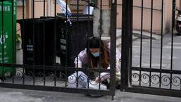 A resident checks plastic bags of food at a residential area under lockdown amid the coronavirus disease (Covid-19) pandemic, in Shanghai, China. (REUTERS)
