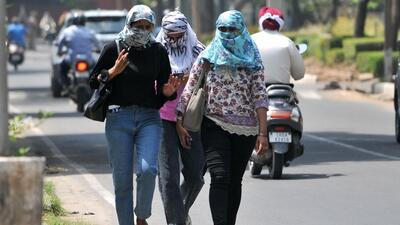 Girls try to beat the heat by covering their face amid searing weather conditions, at Panjab University, Chandigarh, on Sunday. (Ravi Kumar /HT)