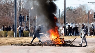 People burn branches to block a road during a riot in Norrkoping, Sweden. (AP) People burn branches to block a road during a riot in Norrkoping, Sweden. (AP)