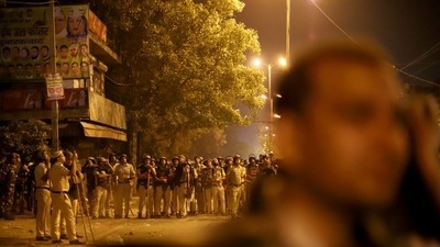 Police personnel stand guard after clashes broke out during a religious procession in Jahangirpuri area of New Delhi. (REUTERS)