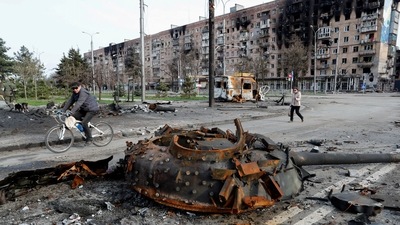 People walk past the turret of a tank, which was destroyed during Ukraine-Russia conflict in the southern port city of Mariupol, Ukraine. (REUTERS)