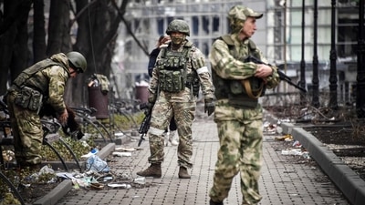 Russian soldiers walk along a street in Mariupol. (AFP) Russian soldiers walk along a street in Mariupol. (AFP)