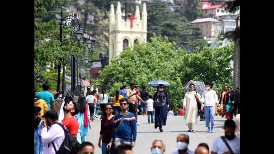 People taking a stroll on a sunny day on The Ridge in Shimla on Sunday. A heatwave may sweep across the state on Monday, the Met department has warned. (Deepak Sansta/HT)