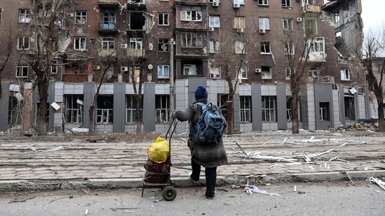 Mariupol: A local resident looks at a damaged apartment building near the Illich Iron & Steel Works Metallurgical Plant. (AP)