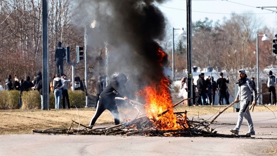 People burn branches to block a road during a riot in Norrkoping, Sweden.(AP)