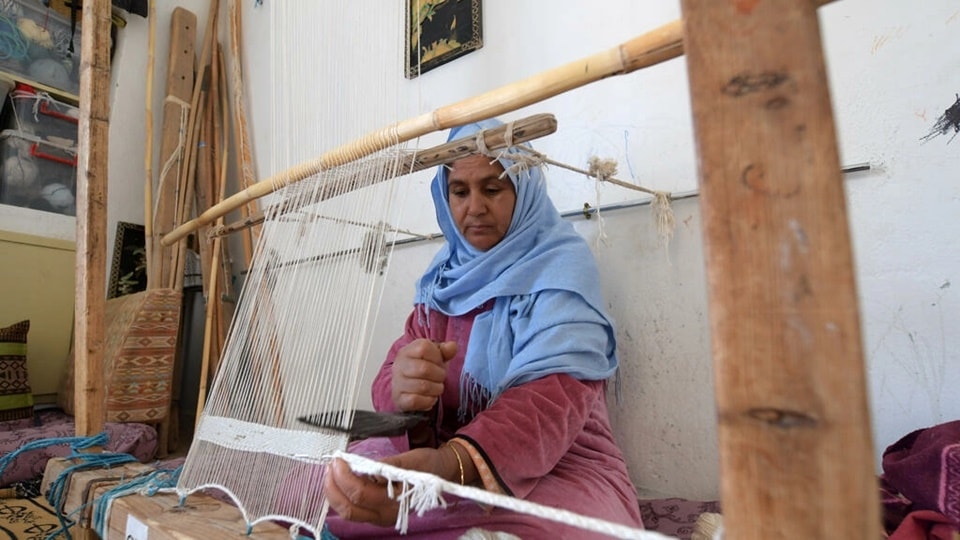 A Tunisian craftswoman weaves a rug at a workshop run by Shanti, a social enterprise that helps artisans from across the North African country&nbsp;(FETHI BELAID AFP)