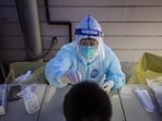 A worker in personal protective equipment collects a swab sample for a round of Covid-19 testing. (Representational image) A worker in personal protective equipment collects a swab sample for a round of Covid-19 testing. (Representational image)
