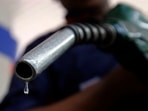 A worker holds a fuel nozzle at a petrol pump in Mumbai&nbsp;