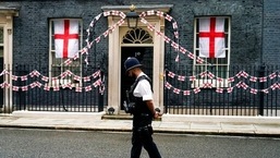 A police officer walks past 10 Downing Street decorated with England flags, in London (AP Photo/Alberto Pezzali)
