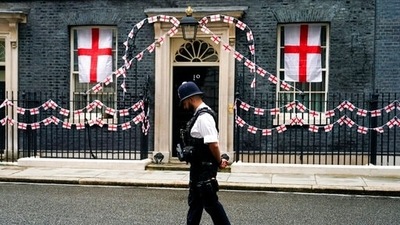 A police officer walks past 10 Downing Street decorated with England flags, in London (AP Photo/Alberto Pezzali) (AP) A police officer walks past 10 Downing Street decorated with England flags, in London (AP Photo/Alberto Pezzali) (AP)