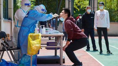 A health worker (left) wearing personal protective equipment conducts a swab test for Covid-19 in a compound in Pudong district in Shanghai on Sunday. (AFP) A health worker (left) wearing personal protective equipment conducts a swab test for Covid-19 in a compound in Pudong district in Shanghai on Sunday. (AFP)